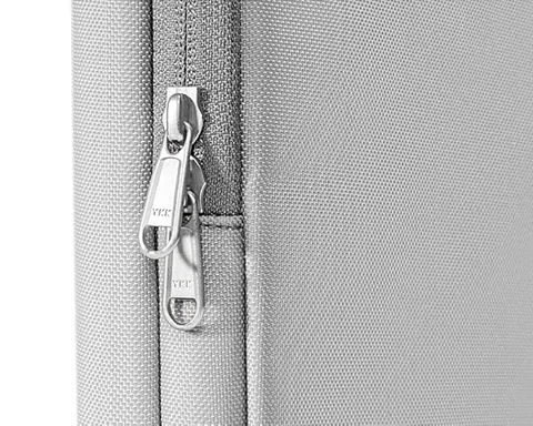 نمای نزدیک زیپ YKK روی یک کاور لپ‌تاپ خاکستری Tomtoc